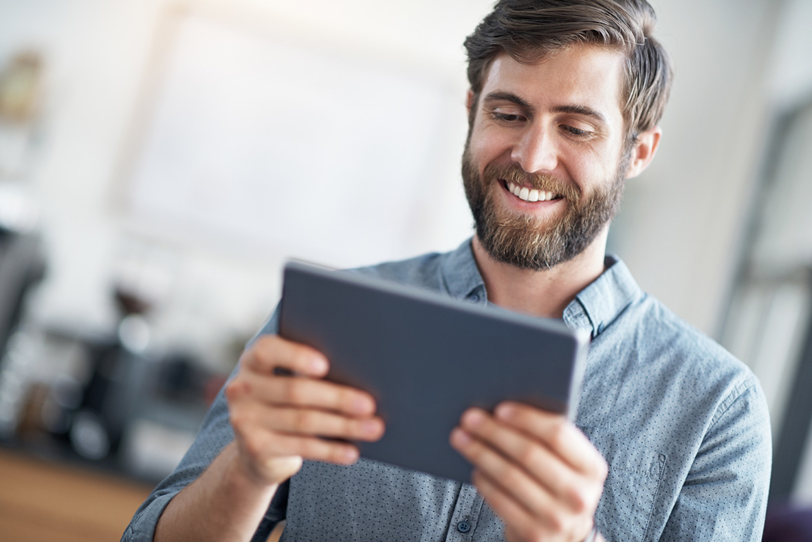 Screenshot: In diesem Bild ist ein lächelnder Mann abgebildet, der ein Tablet hält.